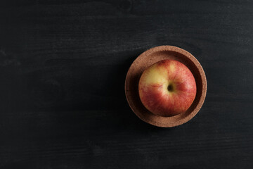 Red juicy apple on a black background. View from above.