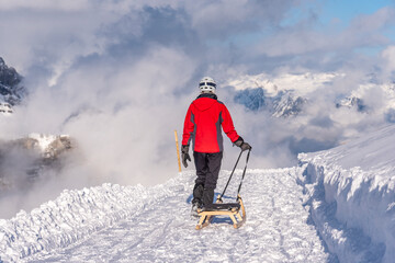 a person with a sledge getting ready to go down the mountain in the alps 