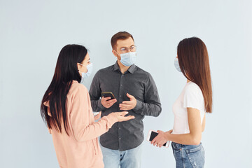 Three people standing together in the studio against white background