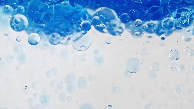 Macro Shot of Various Air Bubbles in Water Rising up on Light White Background. Oxygen Bubbles in Clear Blue Water. Mineral Water. Water Enriched With Oxygen. Slow Motion. High quality FullHD footage