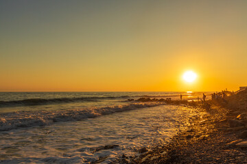 Obraz premium Dark blue waves against the beautiful orange sunset at the Black Sea, Anapa, Russia