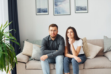 Obraz premium Couple sitting together on the sofa in domestic room
