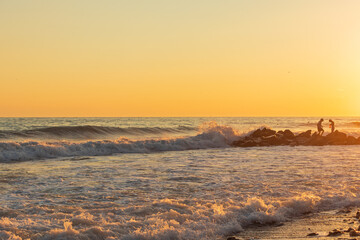 Fototapeta premium Dark blue waves against the beautiful orange sunset at the Black Sea, Anapa, Russia