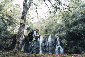 Portrait of a male photographer with a waterfall background.