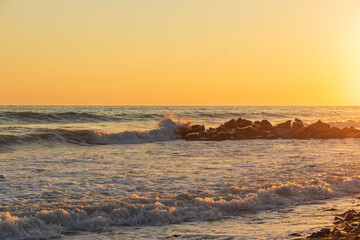 Obraz premium Dark blue waves against the beautiful orange sunset at the Black Sea, Anapa, Russia