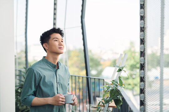 happy man contemplating views with coffee cup on a balcony - Powered by Adobe