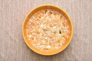 Bowl of muesli with milk on the rustic wooden table. Healthy breakfast. Top view.