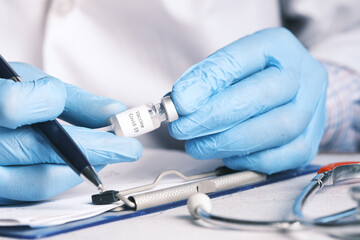 hand in latex gloves holding glass ampoule vaccine, with copy space 