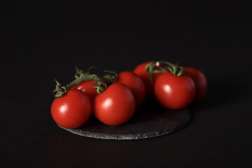 Tomatoes on a slate plate, black background 2