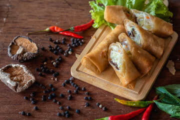 Chinese fried spring rolls on wooden background, stuffed vegetable and minced pork