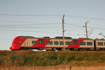 electric train rides on a railroad embankment