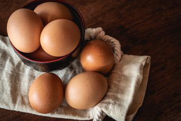 Eggs in the little bowl on the white cloth bag as wooden background for cooking with new recipe