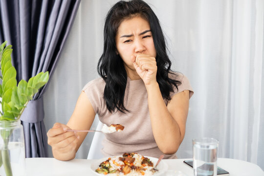 Asian woman choking while eating a meal she has food stuck in the throat and try to vomit or cough