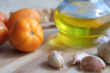 close up of garlic , tomato and olive oil on table 