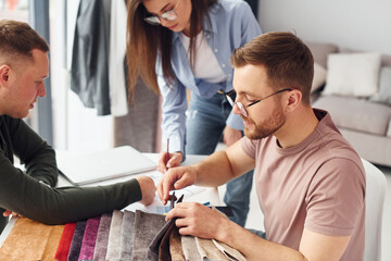 Working with cloth. Having conversation. Group of people works in the office