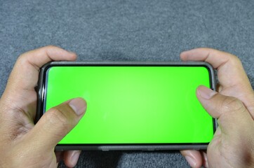 hand holding a smartphone green screen