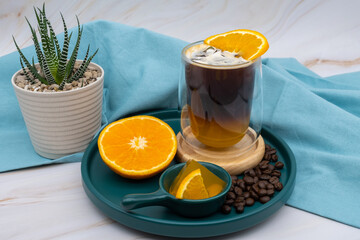 Iced americano black coffee and a layer of orange juice.