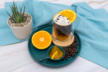 Iced americano black coffee and a layer of orange juice.