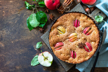 Obraz na płótnie Canvas Apple baking gluten free seasonal. Autumn pie with apples, hazelnut and cinnamon on a wooden table. Top view flat lay background. Copy space.