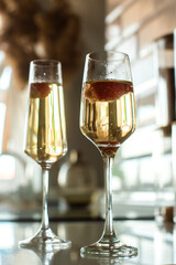 two glasses with champagne and strawberries. light and shadow, silhouette. romantic evening