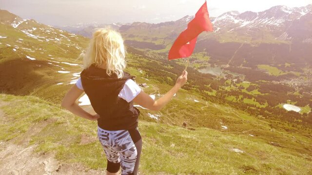 SLOW MOTION sunset Tourist with Swiss flag on Piz Scalottas. Tourist resort for ski activities in winter and bike in summer. Plessur Alps of Switzerland, Chairlift Tgantieni - Piz Scalottas in Grisons