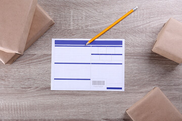 Close up shot of blank shipping application with prepared packages on the table. Waybill with blue...