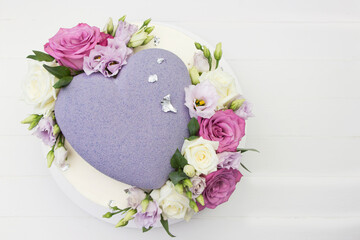 Beautiful wedding cake with purple heart and fresh roses, white background