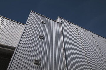 Fototapeta na wymiar Corrugated facade soars into blue sky