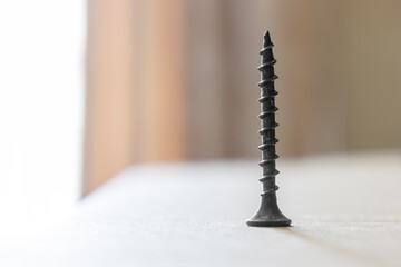 steel black self-tapping screw close-up on defocused background
