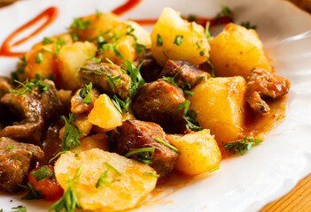 dish of baked potatoes with beef stew with herbs