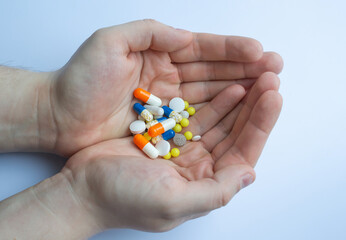 a lot of pills and tablets in the hand, consuming a lot of pills concept