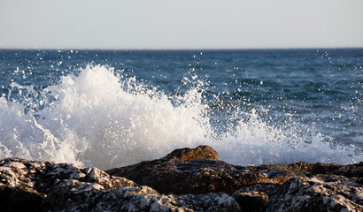 Waves splashed over rocks on a very windy day at sunset (golden hour).