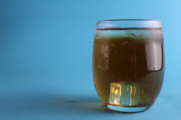 glass of apple juice on a blue background with a place for text and with a copypispe. Summer refreshing cold soft drinks. The field of juice. Natural products