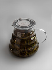 Teapot of milk oolong tea with tea petals on gray background