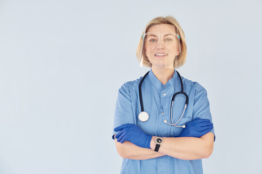 Middle-aged professional female doctor in uniform and with stethoscope