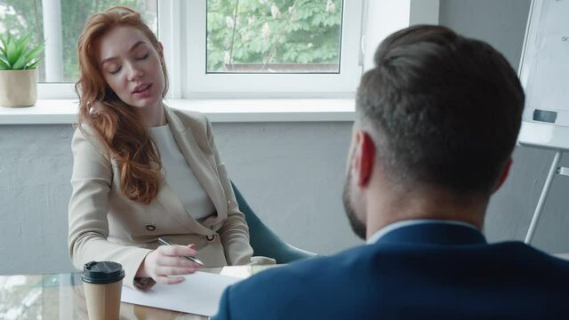 Businesswoman Interviewing Male Job Candidate In Meeting Room. Job HR applicants having an interview with Human resource manager jobs interviewing with confident candidate at business firm office.