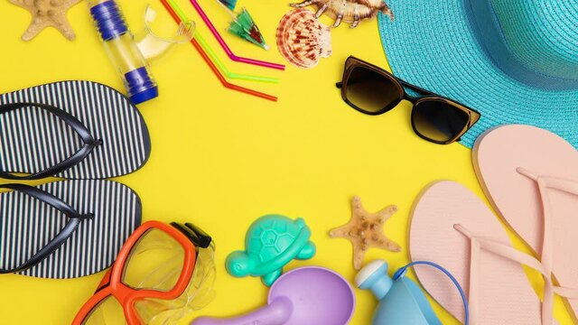 Beach accessories appear on a yellow background. Summer concept. Stop motion animation.