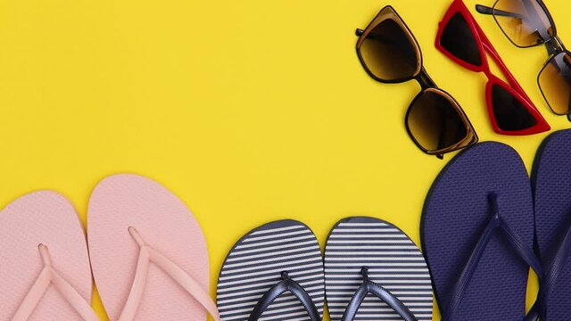 Sunglasses and beach slippers appear on a yellow background. Concept of summer and family fun. Stop motion animation.