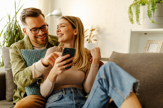 Overjoyed young couple triumph celebrate read good unexpected news on smartphone.
