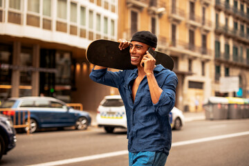 Portrait of happy african-american man with skateboard. Young handsome man with skateboard outdoors..