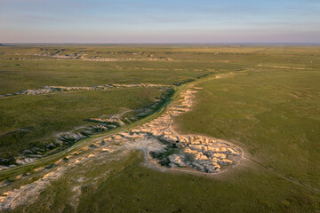sunset light over arroyo and badlands in Pawnee National Grassland in northern Colorado, early...