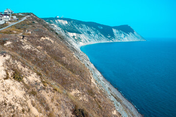 Large and beautiful mountains on the sea coast in the sunlight. Beautiful hills on the seashore with yellow grass from heat.