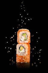 traditional fresh japanese sushi rolls on a black background