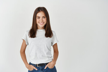 Young smiling woman with happy face looking at camera, standing on white background