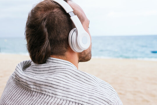 Relaxed Man In Headphones Enjoying Summer Day On Beach