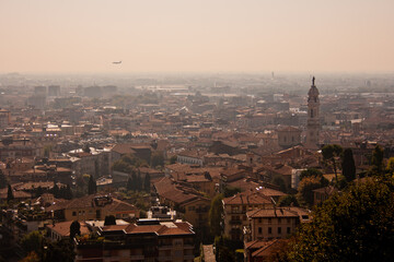 A plane flying over old town of Bergamo in Italy
