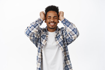 Frustrated african american guy grimacing from failure, shaking hands in denial, clench teeth, painful heartbreaking feeling, suffering distress, standing upset against white background