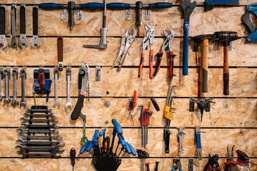 Assorted tools hanging on wall in workshop