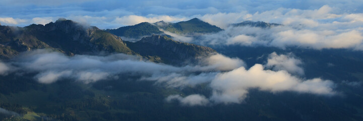 Entlebuch on a morning after rainfall. Clouds and fog lifting over green hills and mountains.