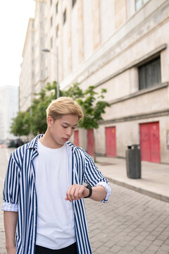 Asian man checking time on wristwatch
